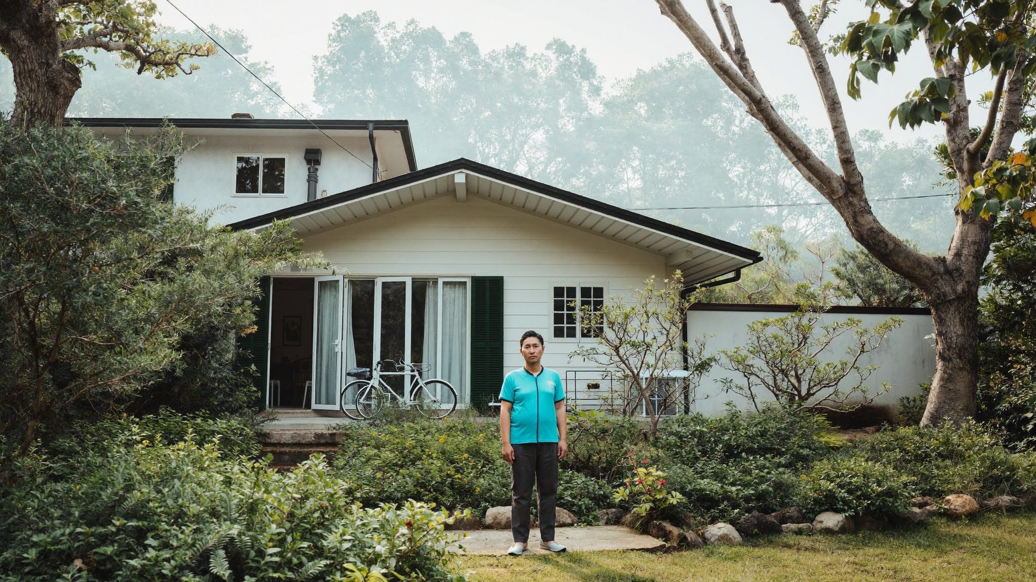 Pemilik rumah di taman depan yang telah disiapkan untuk dijual
